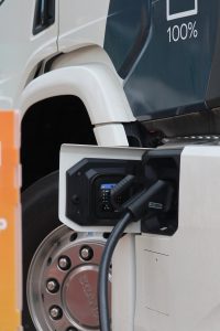 Electric truck charging connector plugged into a Scania heavy transport vehicle