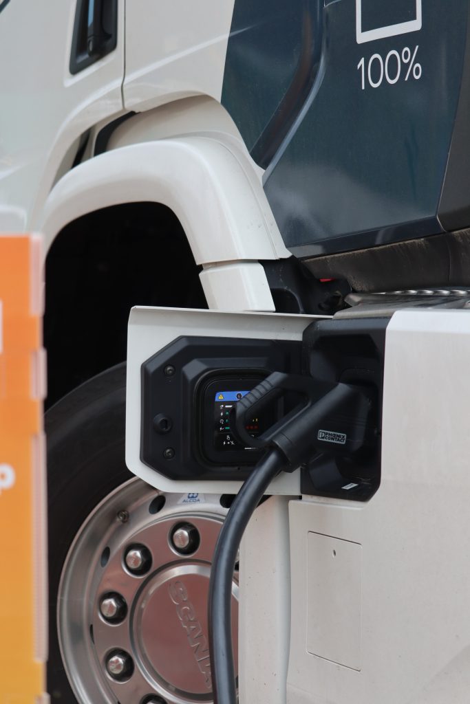 Electric truck charging connector plugged into a Scania heavy transport vehicle