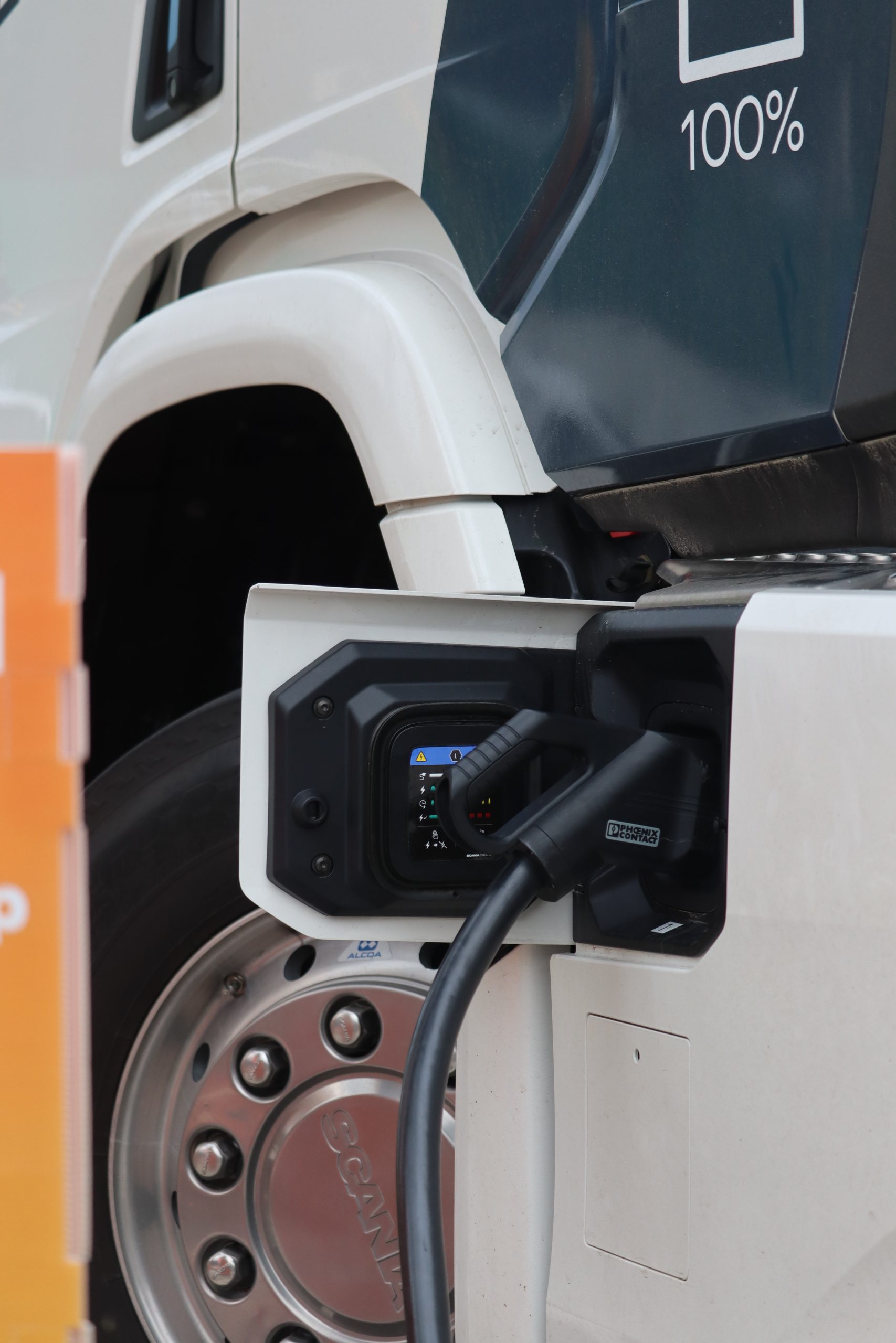 Electric truck charging connector plugged into a Scania heavy transport vehicle